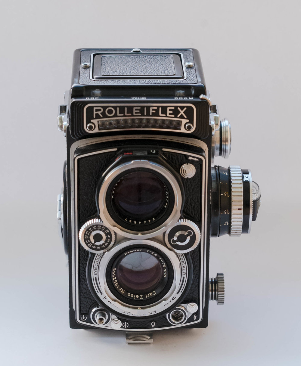 The front of the camera. The wheels are for shutter speed (left) and aperture (right). They can, however, be coupled with a button on the right wheel after an EV (exposure value) has been set with the left wheel to match that shown by the exposure meter. This then gives a range of shutter speed and apertures to match that EV, which is an early form of automatic exposure in my book.